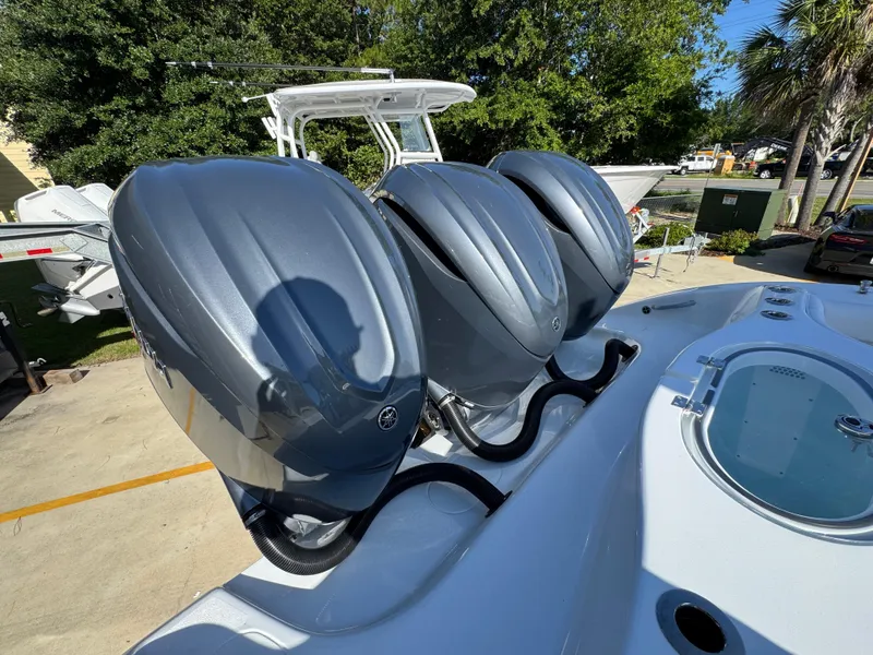 Slide: The Image of 2026 Yellowfin 36 Offshore boat with triple outboard engines, docked outdoors. - 46