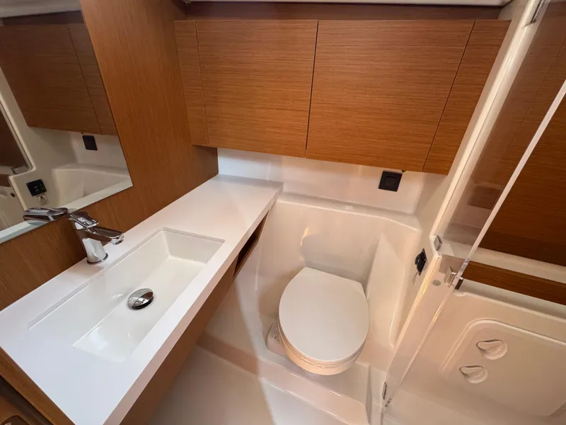 Slide: The Image of 2024 Beneteau First 44 yacht bathroom with modern sink, toilet, and wooden cabinetry. - 11