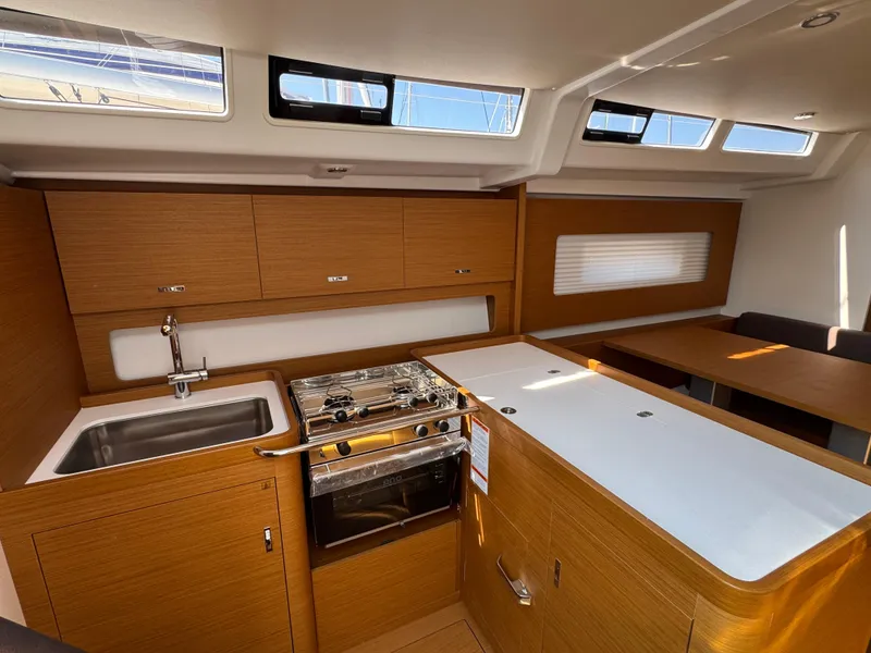 Slide: The Image of 2024 Beneteau First 44 yacht interior with modern kitchen and dining area. - 23