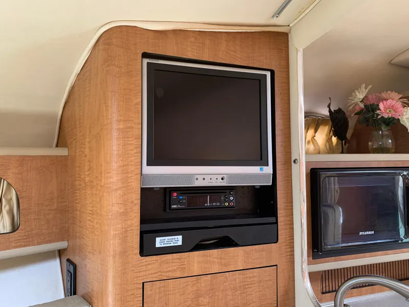 Slide: The Image of 2006 Sea Ray 280 Sundancer interior with TV and floral decor. - 12