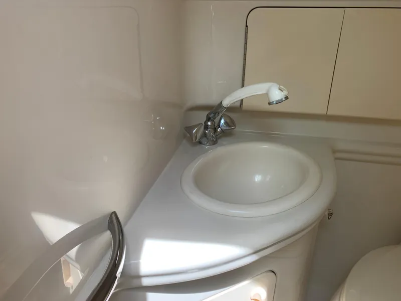 Slide: The Image of 2006 Sea Ray 280 Sundancer bathroom sink with faucet and storage cabinet. - 16