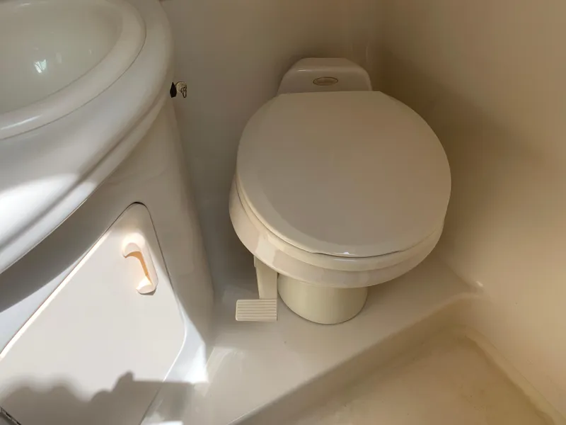 Slide: The Image of Bathroom interior of 2006 Sea Ray 280 Sundancer boat, featuring a compact toilet. - 17