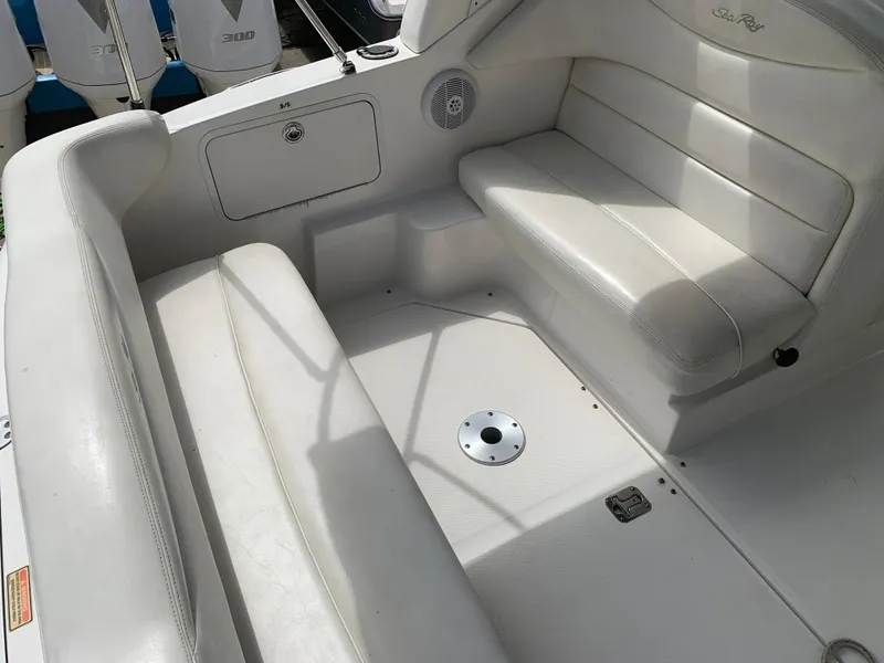 Slide: The Image of 2006 Sea Ray 280 Sundancer boat interior with white seating and storage compartment. - 2