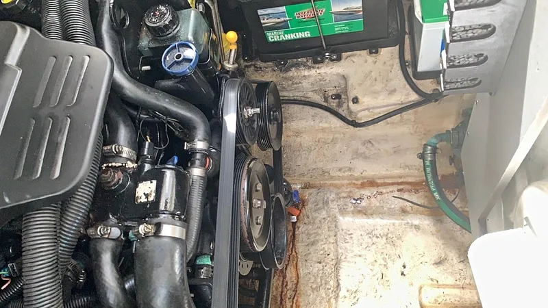 Slide: The Image of Engine compartment of a 2006 Sea Ray 280 Sundancer boat, showing battery and belts. - 21