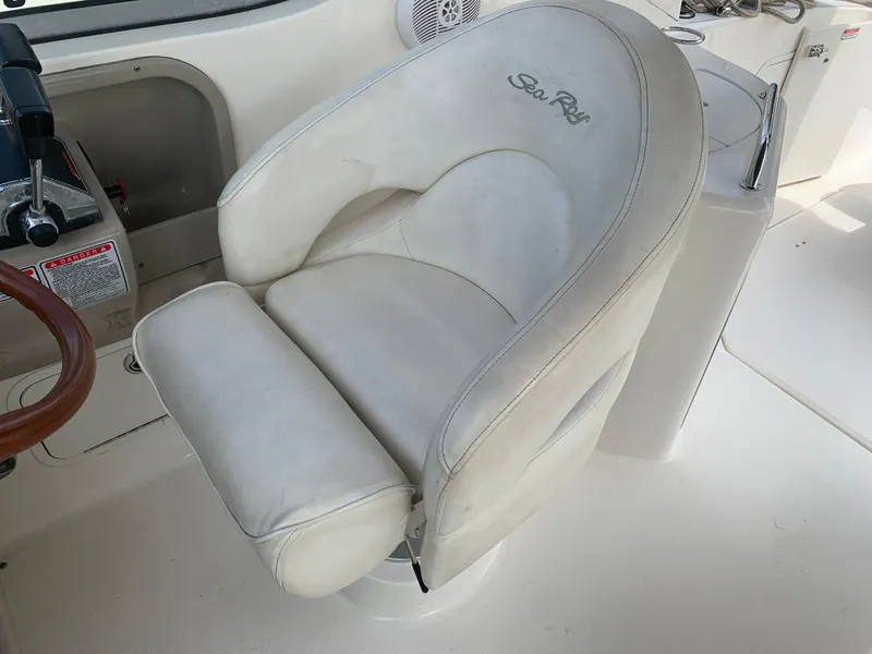 Slide: The Image of Captain's chair on 2006 Sea Ray 280 Sundancer boat, featuring white upholstery and control panel. - 8