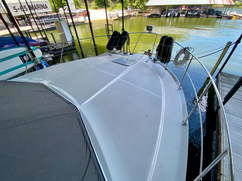 Slide: The Image of 1997 Carver 405 Motor Yacht bow with fenders and anchor, docked on calm water. - 15