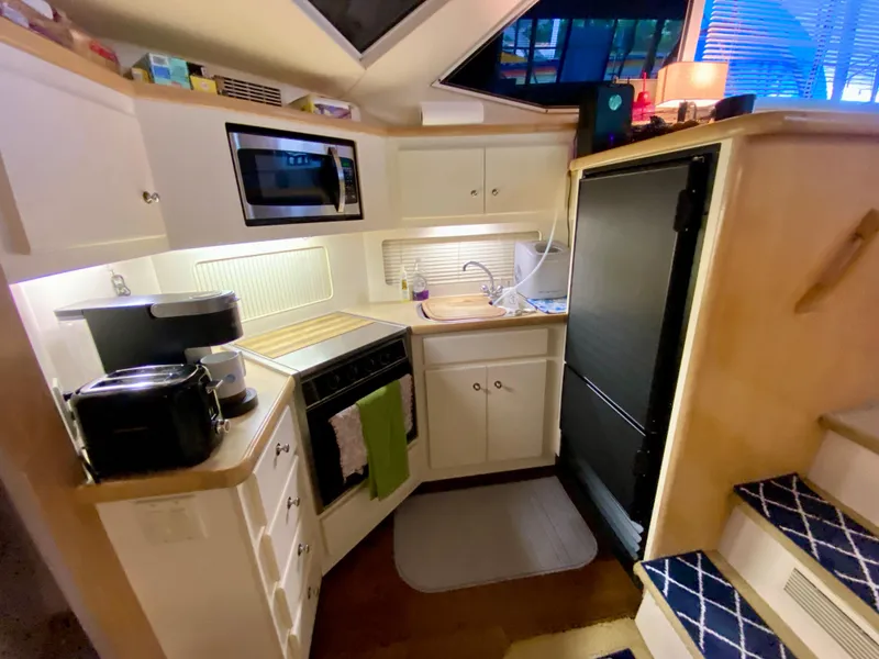 Slide: The Image of Interior of 1997 Carver 405 Motor Yacht with cozy seating and nautical decor. - 23