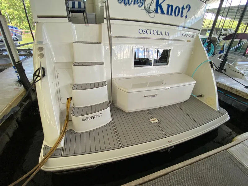 Slide: The Image of 1997 Carver 405 Motor Yacht docked under a covered marina with American flag. - 4