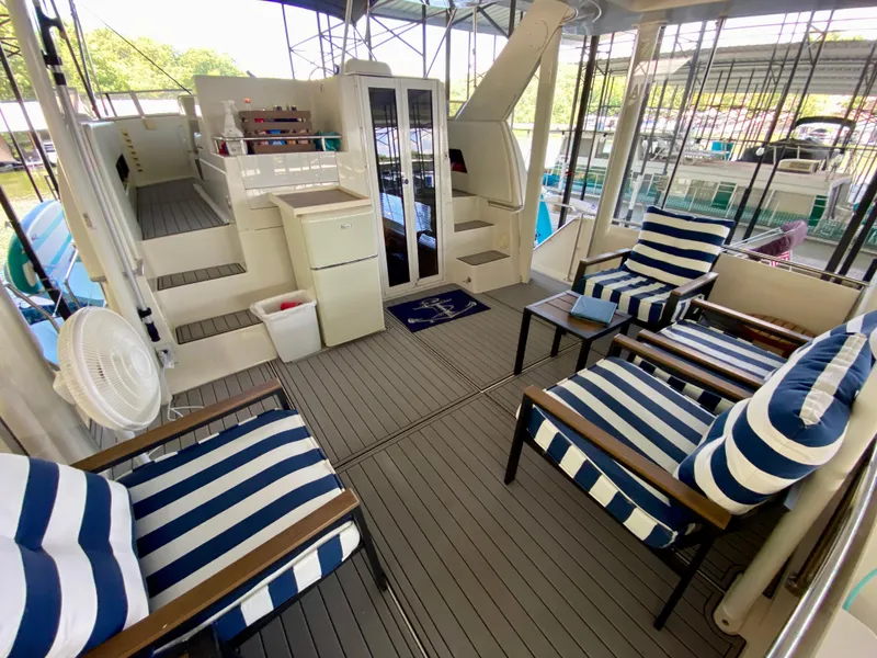 Slide: The Image of 1997 Carver 405 Motor Yacht interior with striped seating and marina view. - 6