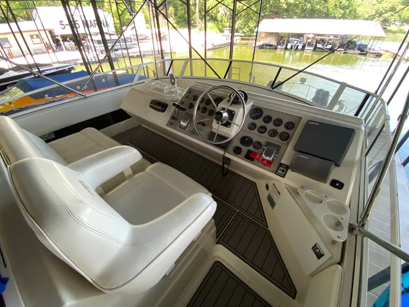 Slide: The Image of 1997 Carver 405 Motor Yacht interior with white seating and steering area. - 9