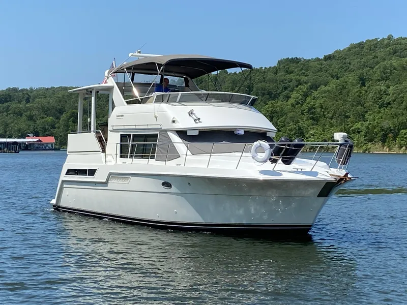 Slide: The Image of 1997 Carver 405 Motor Yacht docked in marina, rear view with "Why Knot?" name. - 2