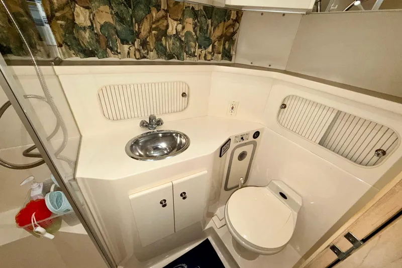 Slide: The Image of 1997 Carver 405 Motor Yacht bathroom with sink, toilet, and storage cabinets. - 39