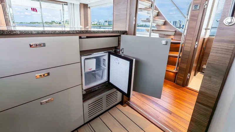 Slide: The Image of Luxurious 2024 Princess X80 yacht interior with open mini fridge and elegant wood flooring. - 23