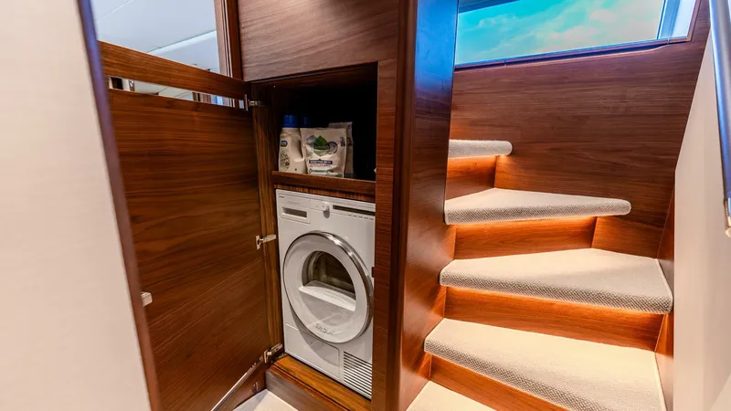 Slide: The Image of Laundry area with washing machine on 2024 Princess X80 yacht, near carpeted stairs. - 40