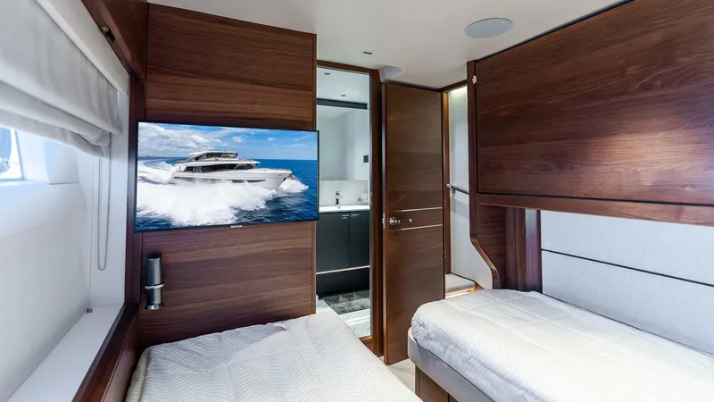 Slide: The Image of Luxurious 2024 Princess X80 yacht cabin with twin beds and modern wood paneling. - 46