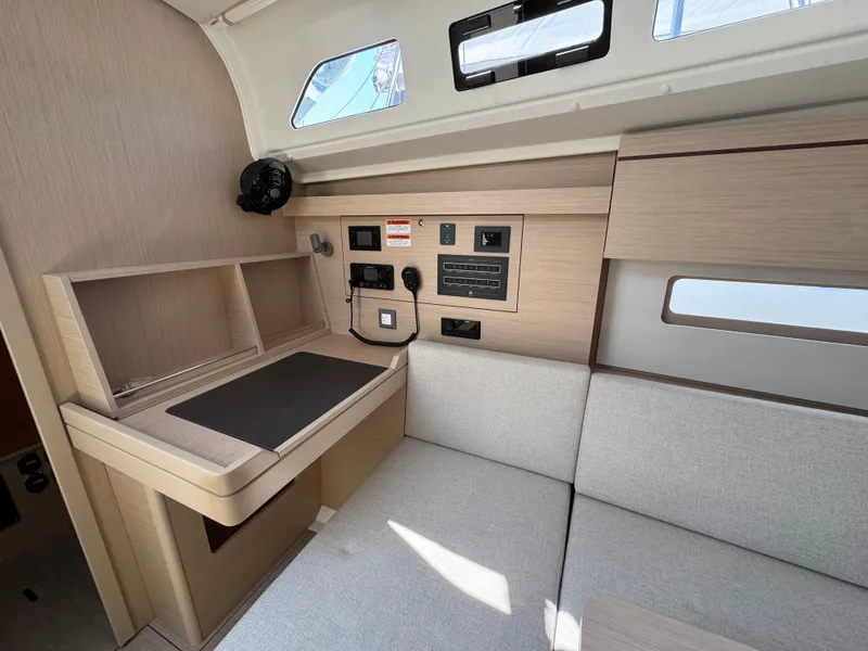 Slide: The Image of 2025 Beneteau Oceanis 40.1 interior with navigation station and modern light wood finish. - 8