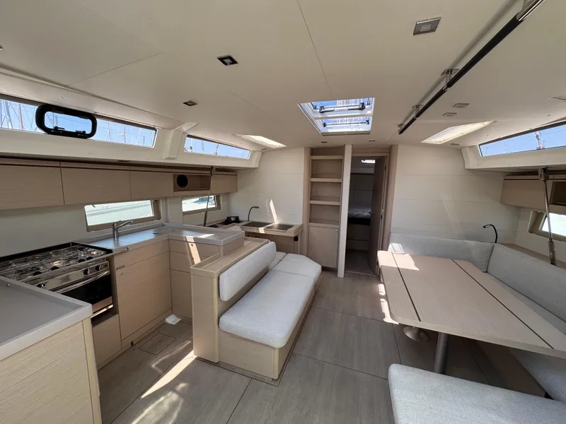 Slide: The Image of 2024 Beneteau Oceanis 51.1 yacht interior with modern kitchen and dining area. - 15