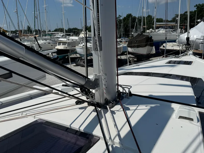Slide: The Image of Beneteau Oceanis 51.1 sailboat deck, 2024 model, in a marina with other boats. - 2