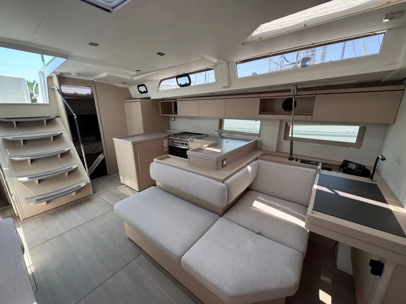 Slide: The Image of 2024 Beneteau Oceanis 51.1 interior with modern kitchen, seating, and natural light. - 9