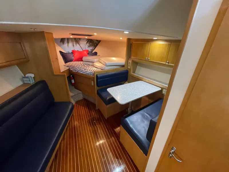 Slide: The Image of Interior of 1998 Hatteras 39 Sport Express, featuring cozy seating and wooden finishes. - 10
