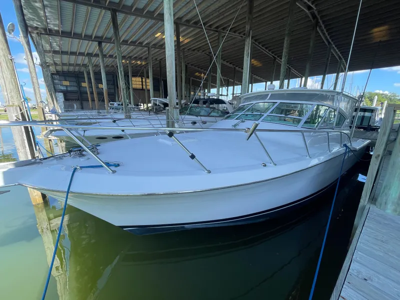 Slide: The Image of 1998 Hatteras 39 Sport Express boat docked in a covered marina. - 11
