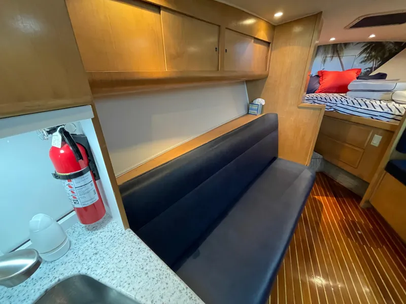 Slide: The Image of Interior of 1998 Hatteras 39 Sport Express with seating, fire extinguisher, and wooden cabinetry. - 13