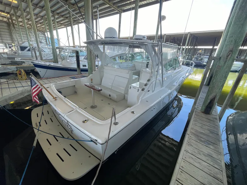 Slide: The Image of 1998 Hatteras 39 Sport Express yacht docked in a marina, rear view. - 14