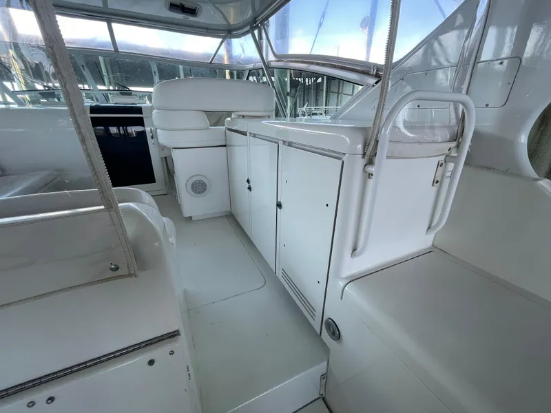 Slide: The Image of 1998 Hatteras 39 Sport Express interior with white seating and storage cabinets. - 17