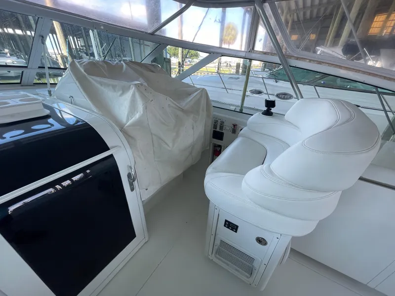 Slide: The Image of 1998 Hatteras 39 Sport Express cockpit with white seating and covered controls. - 19