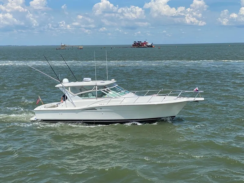 Slide: The Image of 1998 Hatteras 39 Sport Express cruising on open water under a partly cloudy sky. - 2