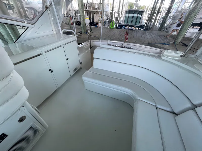 Slide: The Image of 1998 Hatteras 39 Sport Express interior with white seating and cabinetry in a marina setting. - 21