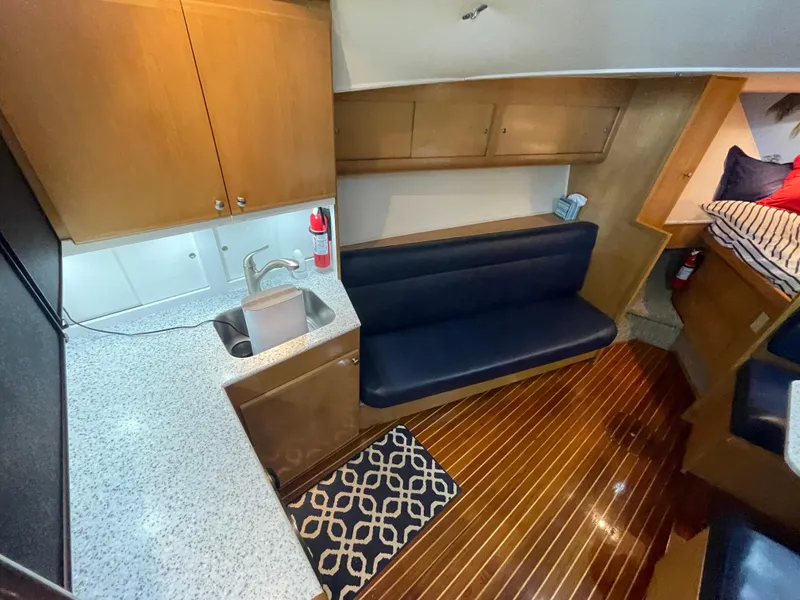 Slide: The Image of 1998 Hatteras 39 Sport Express interior with kitchenette, seating, and wooden flooring. - 24