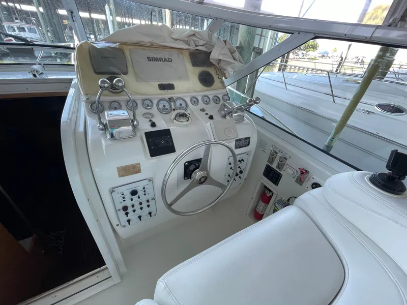 Slide: The Image of 1998 Hatteras 39 Sport Express helm with steering wheel and navigation controls. - 29