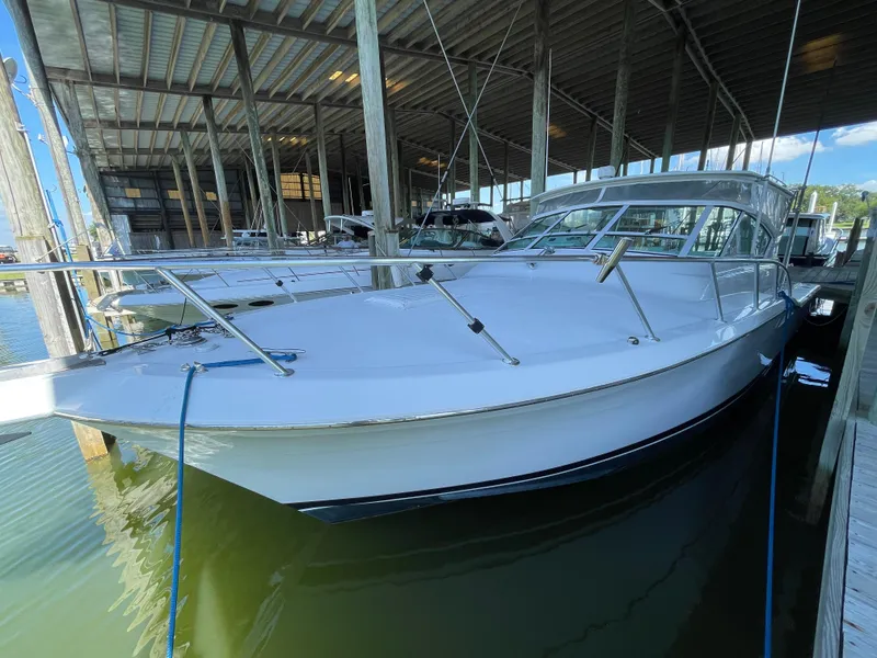 Slide: The Image of 1998 Hatteras 39 Sport Express docked under covered marina. - 33