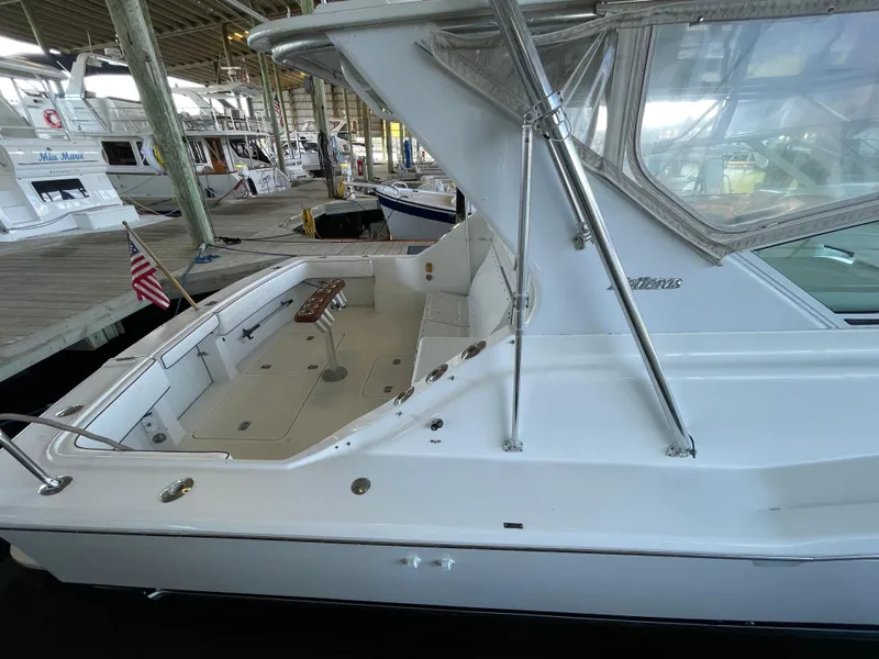 Slide: The Image of 1998 Hatteras 39 Sport Express yacht docked in a marina, featuring a spacious deck area. - 34