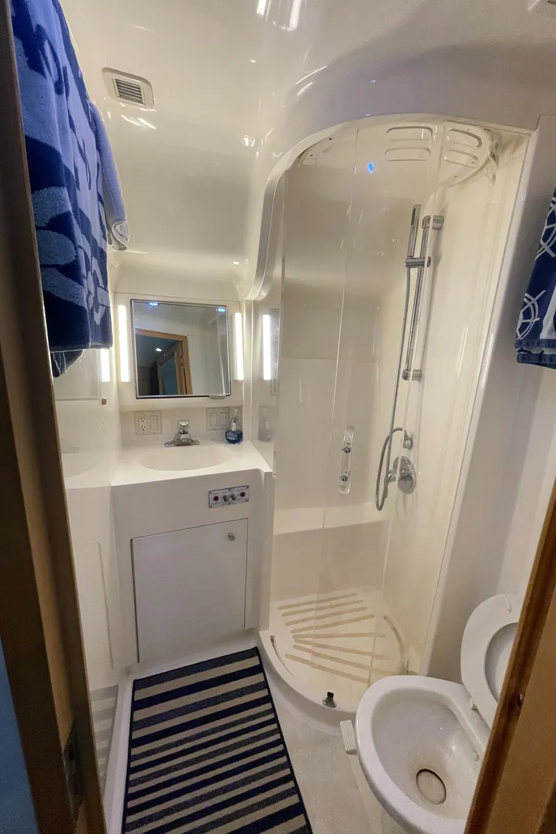 Slide: The Image of Bathroom interior of 1998 Hatteras 39 Sport Express yacht, featuring shower, sink, and toilet. - 37
