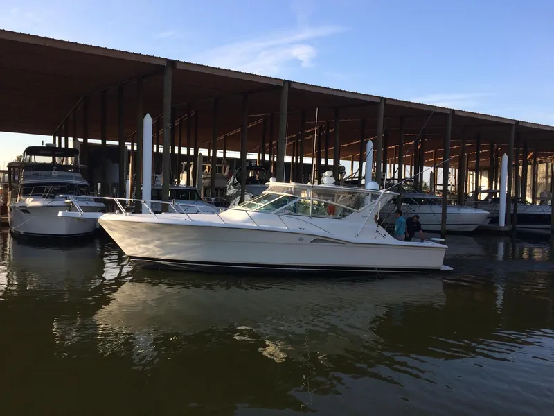Slide: The Image of 1998 Hatteras 39 Sport Express yacht docked in marina under covered shelter. - 5