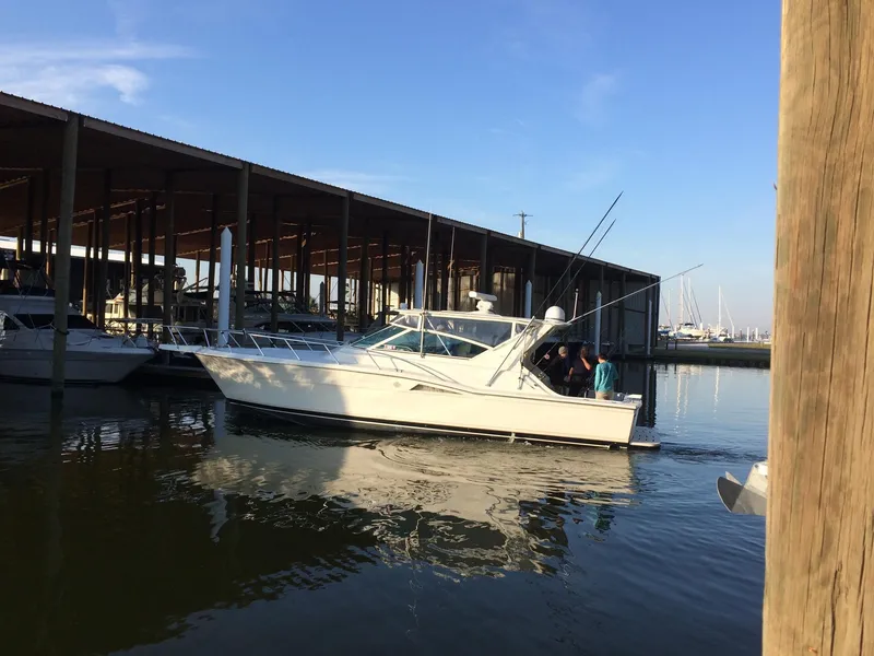 Slide: The Image of 1998 Hatteras 39 Sport Express boat docked at marina under clear blue sky. - 6