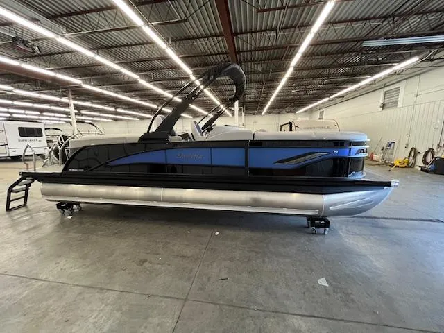 Slide: The Image of 2025 Barletta CORSA 23QC pontoon boat in a spacious indoor showroom. - 1