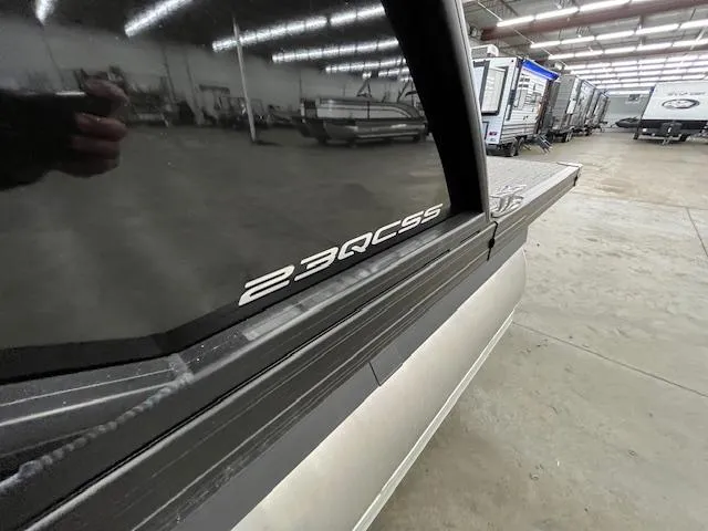 Slide: The Image of 2025 Barletta CORSA 23QC pontoon boat in showroom, side view with model decal. - 3