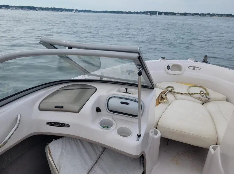 Slide: The Image of 2007 Tahoe Q6 Tracker boat interior with seating and dashboard on a calm lake. - 6
