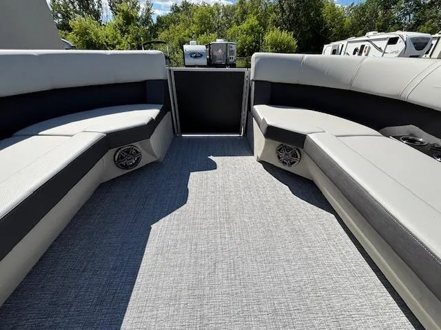 Slide: The Image of 2025 Harris Cruiser 230 interior with gray seating and speakers, surrounded by lush greenery. - 25