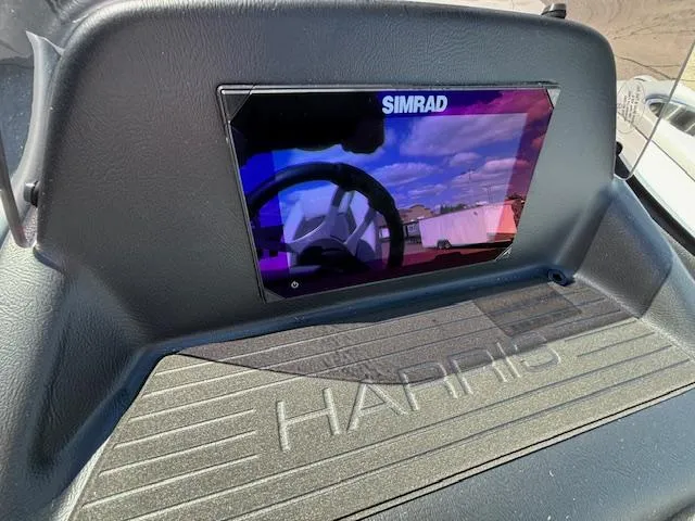 Slide: The Image of Simrad display on 2025 Harris Cruiser 230 dashboard, reflecting sky and surroundings. - 26