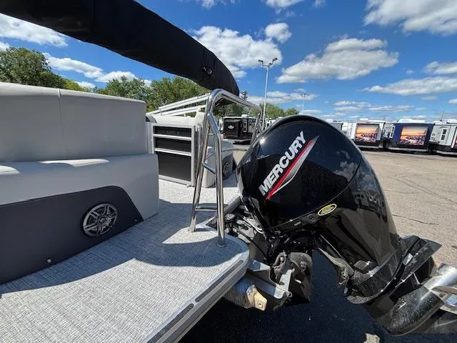 Slide: The Image of 2025 Harris Cruiser 230 pontoon boat with Mercury outboard motor, parked outdoors. - 6