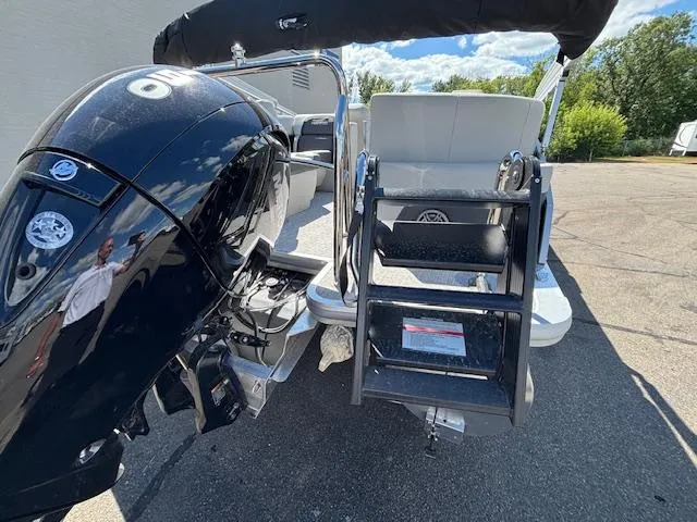 Slide: The Image of 2025 Harris Cruiser 230 boat with outboard motor and boarding ladder, parked outdoors. - 8