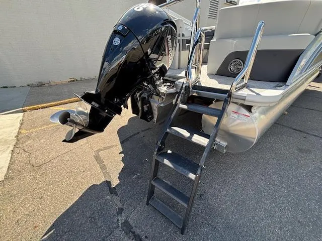 Slide: The Image of 2025 Harris Cruiser 230 boat with outboard motor and boarding ladder. - 9