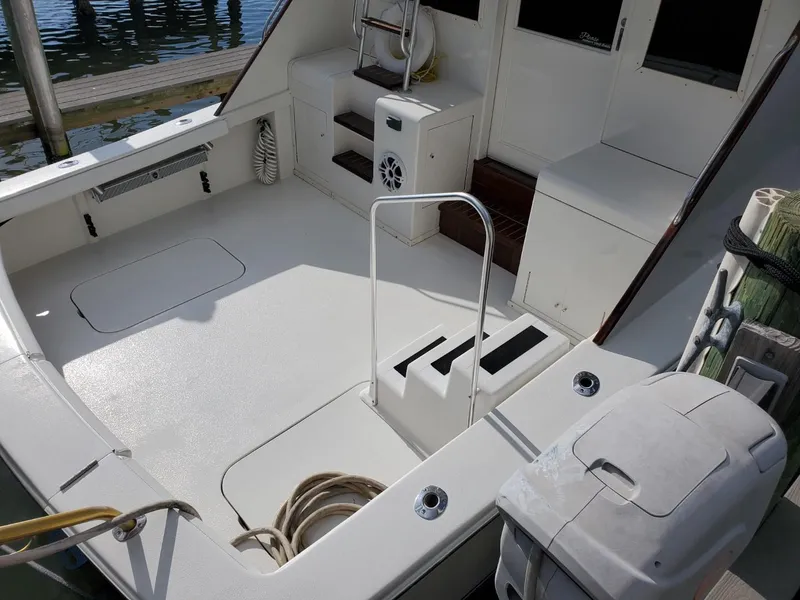 Slide: The Image of 1988 Post 46 Sportfish boat deck with ladder and seating area, docked at marina. - 10