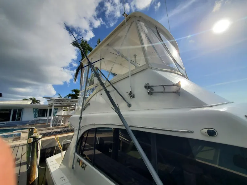 Slide: The Image of 1988 Post 46 Sportfish yacht docked in a scenic waterfront setting. - 5