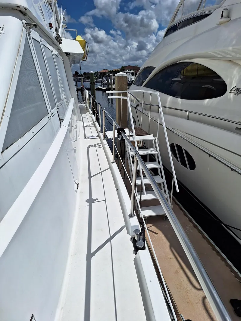 Slide: The Image of 1988 Viking Motor Yacht docked beside another yacht under a partly cloudy sky. - 6