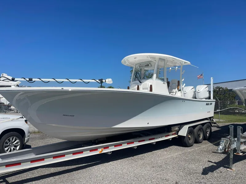 The Image of 2026 Regulator 30XO boat on trailer, clear sky background, American flag visible. - 0